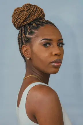 Long box braids gathered into a high braided bun restyled
